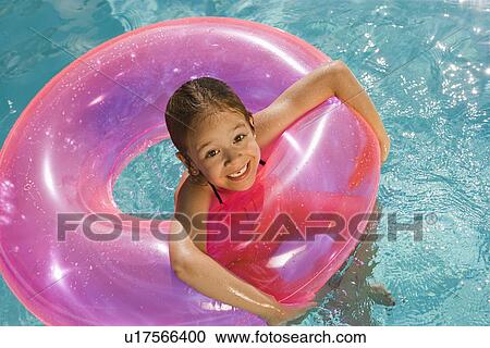 Stock Image - Girl Inside Pink Float Tube in Pool. Fotosearch