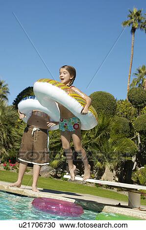 Girl jumping into swimming pool with inflatable raft View Large Photo Image Stock Image - Girl jumping into swimming pool with inflatable raft. Fotosearch