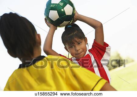 Picture - Girl soccer player (7-9 years) preparing to throw ball. Fotosearch