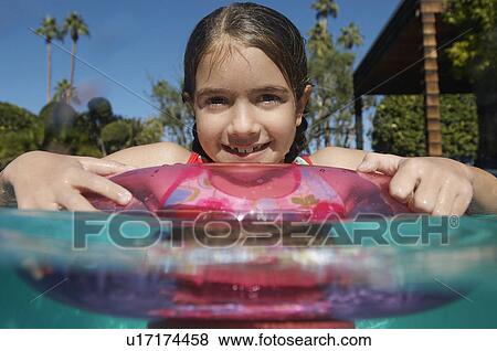 Stock Photo - Girl with inflatable raft in swimming pool. Fotosearch