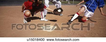 Stock Image - Girls (13-17) playing baseball, low section. Fotosearch