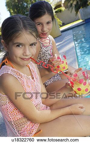 Girls drinking juice from crazy straws on edge of swimming pool, portrait View Large Photo Image Stock Image - Girls drinking juice from crazy straws on edge of swimming pool, portrait. Fotosearch