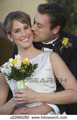 Groom kissing bride from behind View Large Photo Image Stock Image - Groom kissing bride from behind. Fotosearch