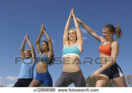 Stock Photograph - Group exercising with instructor in park. Fotosearch