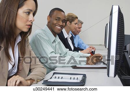 Group of business people using computers in classroom, side view View Large Photo Image Stock Image - Group of business people using computers in classroom, side view. Fotosearch