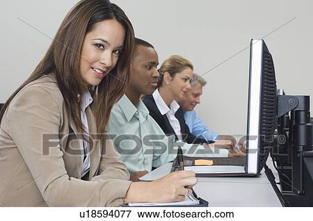 Stock Photo - Group of business people using computers in classroom, side view. Fotosearch