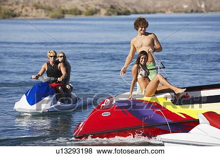 Stock Photo - Group of friends on boats at lake. Fotosearch