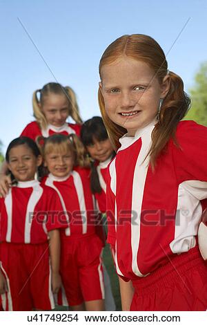 Picture - Group of girl soccer players (7-9 years) standing on field, portrait. Fotosearch