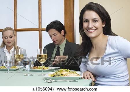 Stock Photo - Group of people in restaurant, one woman looking at camera. Fotosearch