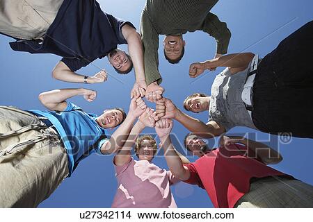 Picture - Group of young men in circle, view from below. Fotosearch