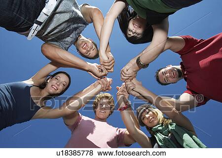 Stock Photo - Group of young people in circle, view from below. Fotosearch