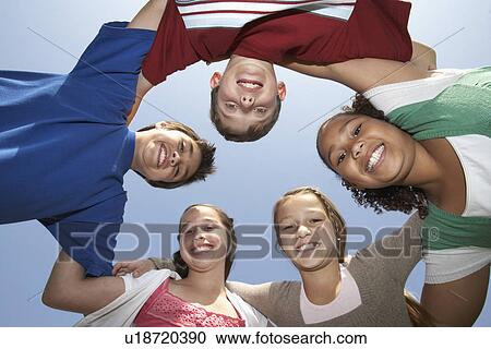 Stock Image - Group portrait of boys and girls standing in circle, view from below. Fotosearch