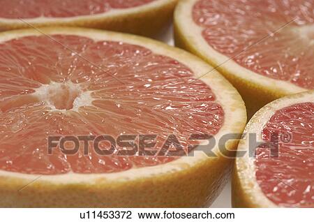 Stock Image - Halved grapefruits, close-up. Fotosearch