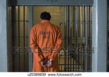 Stock Photo - Handcuffed prisoner in jail. Fotosearch