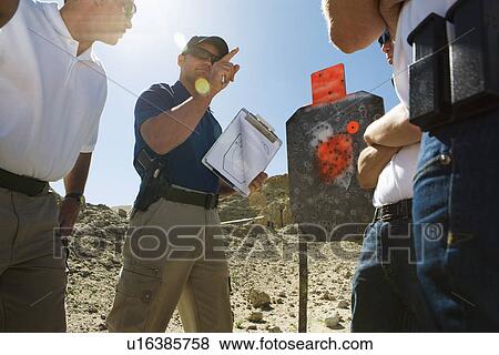 Instructor holding clipboard with target diagram at combat training View Large Photo Image Stock Photo - Instructor holding clipboard with target diagram at combat training. Fotosearch