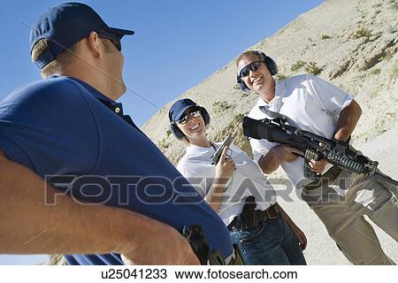Instructor with couple at firing range in desert View Large Photo Image Stock Image - Instructor with couple at firing range in desert. Fotosearch