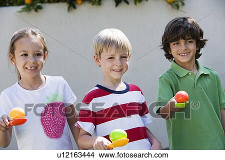 Picture - Kids Holding Eggs in Spoons for Egg Race. Fotosearch