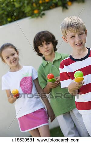Stock Image - Kids Holding Eggs in Spoons for Egg Race. Fotosearch
