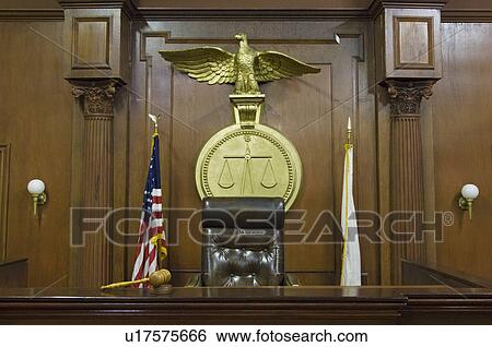 Stock Photograph - Legal scales behind judges chair in court. Fotosearch