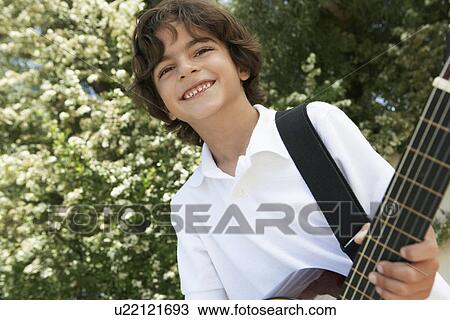 Stock Image - Little Boy Playing Guitar. Fotosearch
