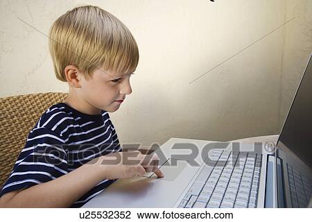 Stock Image - Little Boy Using a Laptop. Fotosearch