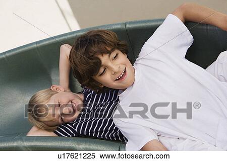 Stock Photography - Little Boys Sliding down a Slide. Fotosearch