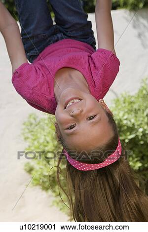 Stock Image - Little Girl Hanging Upside Down. Fotosearch