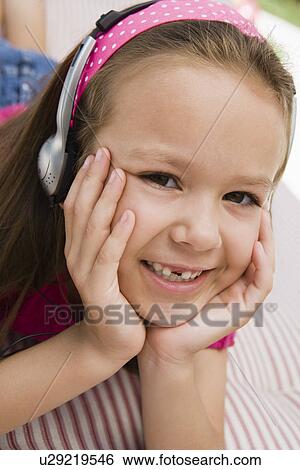 Stock Photograph - Little Girl Listening to Headphones. Fotosearch