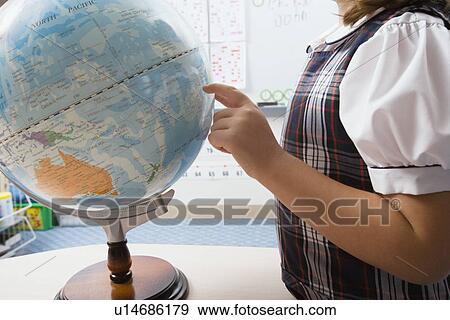 Stock Photo - Little Girl Pointing to Globe. Fotosearch