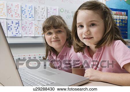 Stock Image - Little Girls Using a Laptop. Fotosearch