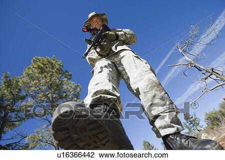 Stock Image - Low angle portrait of armed soldier. Fotosearch