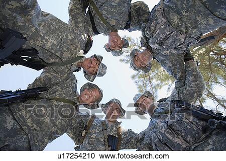 Stock Image - Low angle portrait of soldiers standing in circle. Fotosearch