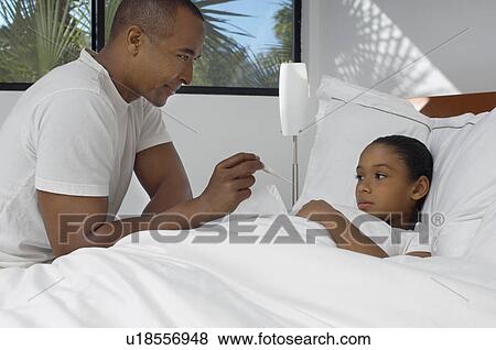 Male nurse taking temperature of girl (7-9) lying in bed View Large Photo Image Stock Photo - Male nurse taking temperature of girl (7-9) lying in bed. Fotosearch