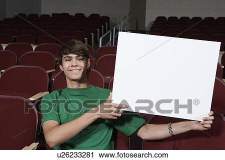 Male student holding blank board in lecture theatre, portrait View Large Photo Image Stock Image - Male student holding blank board in lecture theatre, portrait. Fotosearch