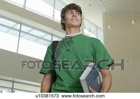 Male student holding book in university View Large Photo Image Stock Image - Male student holding book in university. Fotosearch