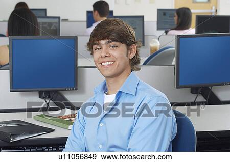 Stock Photo - Male student sitting in computer classroom, portrait. Fotosearch