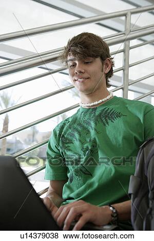Male student using laptop on stairs View Large Photo Image Stock Photo - Male student using laptop on stairs. Fotosearch