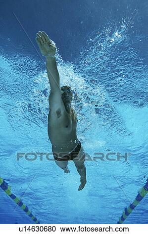 Stock Image - Male swimmer in pool, underwater view. Fotosearch