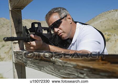 Man aiming machine gun at firing range View Large Photo Image Stock Image - Man aiming machine gun at firing range. Fotosearch