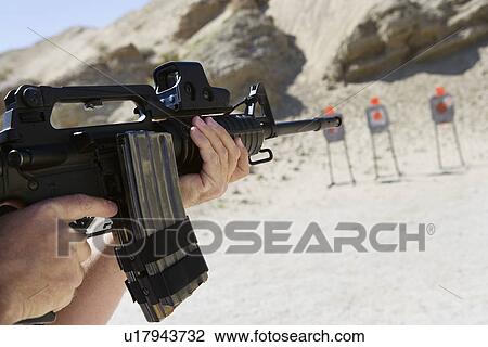 Man aiming machine gun at firing range, close up of hands View Large Photo Image Stock Image - Man aiming machine gun at firing range, close up of hands. Fotosearch