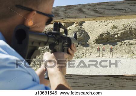 Man aiming machine gun at firing range View Large Photo Image Stock Photography - Man aiming machine gun at firing range. Fotosearch