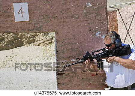 Man aiming machine gun at firing range View Large Photo Image Stock Photography - Man aiming machine gun at firing range. Fotosearch