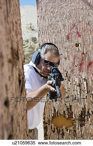 Man aiming machine gun at firing range View Large Photo Image Stock Photography - Man aiming machine gun at firing range. Fotosearch