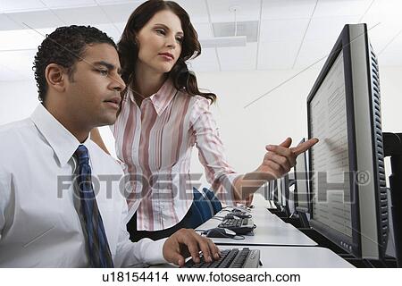 Picture - Man and woman using computer together. Fotosearch