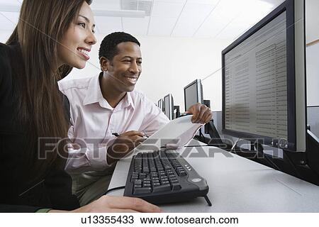 Man and woman using computer together View Large Photo Image Stock Image - Man and woman using computer together. Fotosearch