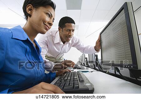 Stock Photography - Man and woman using computer together. Fotosearch