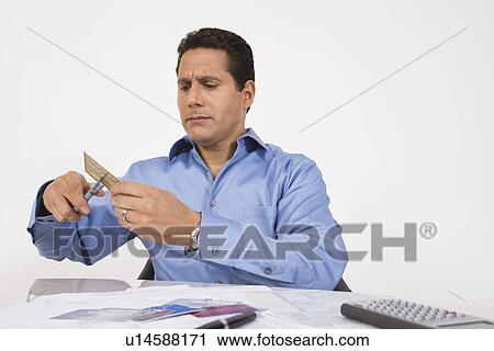 Stock Image - Man Cutting up a Credit Card. Fotosearch