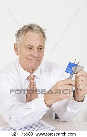 Stock Photo - Man Cutting up Credit Card. Fotosearch