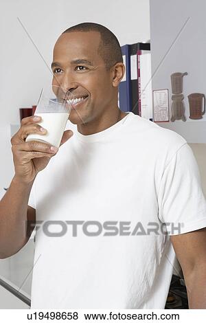 Stock Photo - Man drinking milk in office. Fotosearch