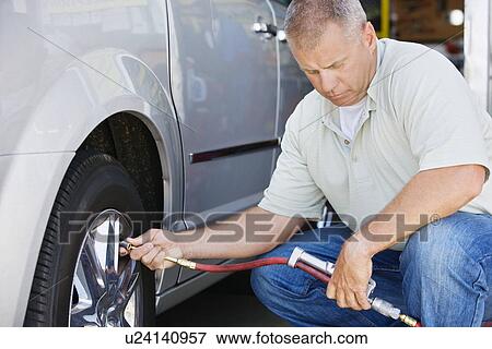 Stock Photo - Man Filling Tires on RV. Fotosearch